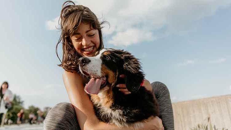 Smiling woman holding her dog